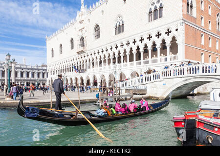 Gondel mit bunten Touristen in rosa jacken vor dem Dogenpalast, Venedig, Italien unter der Ponte della Paglia zu übergeben Stockfoto