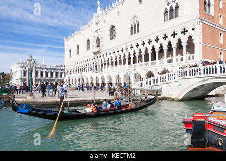 Gondel mit Touristen vor dem Dogenpalast oder Palazzo Ducale,, Venedig, Italien über die Zeile unter dem Ponte della Paglia Stockfoto