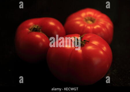 Drei rote heirloom Tomaten frisch aus dem Garten. Stockfoto