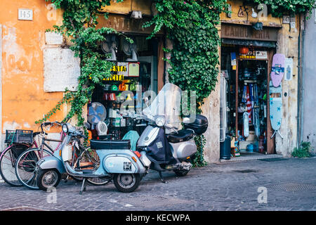 Fahrräder und Motorroller außerhalb eines alten, traditionellen Hardware/Haushaltswaren Shop im historischen Zentrum von Rom, Italien Stockfoto