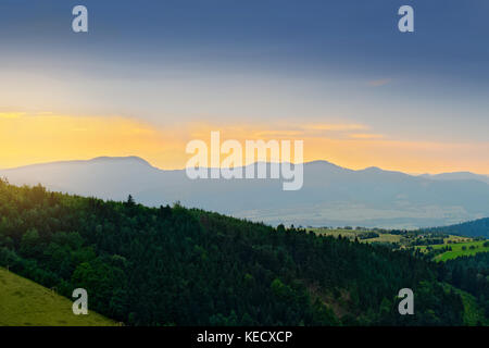 Weites panorama Blick auf nebligen Tal im Eulengebirge mit Silhouette der Sudeten Berge in der Abenddämmerung. Landschaft Landschaft im Südwesten Polens. Stockfoto