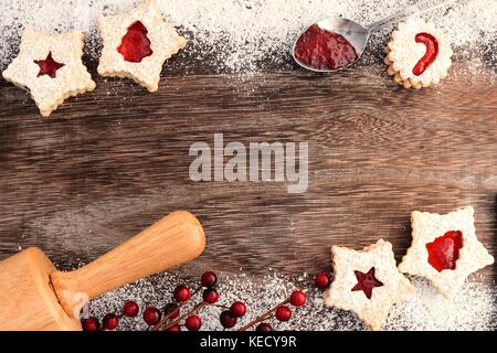 Weihnachten backen Doppel Grenze auf einer hölzernen Hintergrund mit Linzer Marmelade cookies Stockfoto