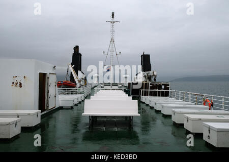 Blick von hinten oder hinten auf Baldur Autofähre Passagierstühle, Sitze und Rettungsboot an bewölktem Tag auf See mit isländischer Flagge segelnd in Richtung Flatey Stockfoto