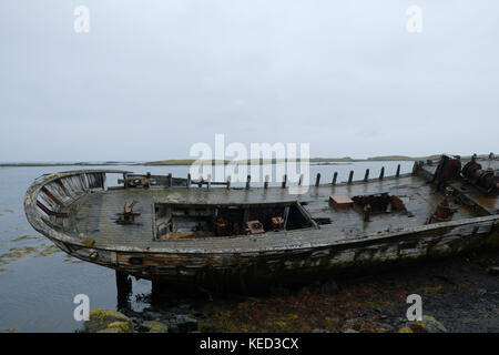 Altes Schiffswrack an der Küste mit verfallendem Holz auf der abgelegenen Insel Flatey in Island Stockfoto