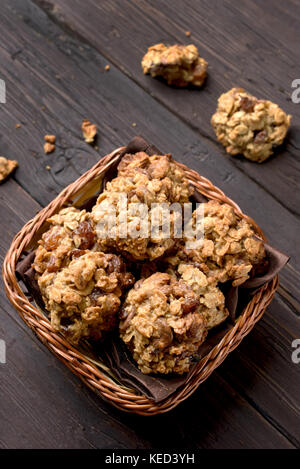 Gesunde Hafer Cookies im Weidenkorb über Holz- Hintergrund, Ansicht von oben Stockfoto