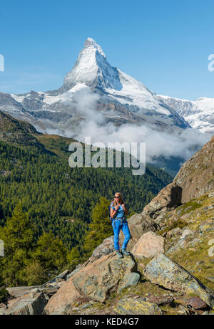 Wanderer steht auf Felsen, Schnee auf der Rückseite das Matterhorn, Wallis, Schweiz Stockfoto