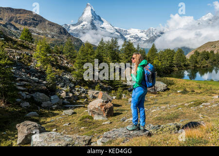 Wanderer steht auf Felsen und in die Ferne schaut, hinter grindijsee und schneebedeckten Matterhorn, Wallis, Schweiz Stockfoto