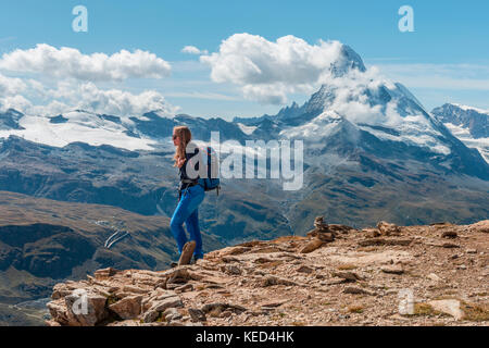 Wanderer steht auf Felsen, Schnee auf der Rückseite das Matterhorn, Wallis, Schweiz Stockfoto