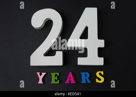 Buchstaben und Zahlen 24 Jahre auf einem schwarzen Hintergrund isoliert. Stockfoto