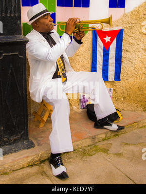 Entlang einer engen Straße in Havanna Vieja ein solo Trompeter unterhält der Touristen für einen Tipp. Stockfoto