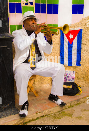 Entlang einer engen Straße in Havanna Vieja ein solo Trompeter unterhält der Touristen für einen Tipp. Stockfoto