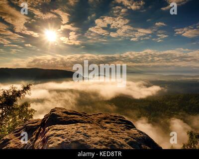 Querformat. Freiliegende Sandstein Klippen über tiefe misty Valley in Sächsische Schweiz. verträumte Stimmung im Morgengrauen nach stürmische Nacht. Stockfoto