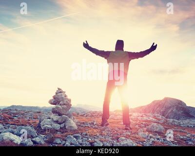 Touristische in grün Outdoor Jacke auf Rocky View Point. gestapelt gebrochene Steine in Pyramide. Nationalpark Alpen Park in Österreich Deutschland Grenze. sonnigen Herbst Stockfoto