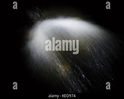 Shinning fällt. Kaskade kleiner Wehr am Gebirgsbach, Wasser läuft über Bausteine und Blasen erstellen Milky smoky Wasserstand. Abstrakt, lange Expo Stockfoto