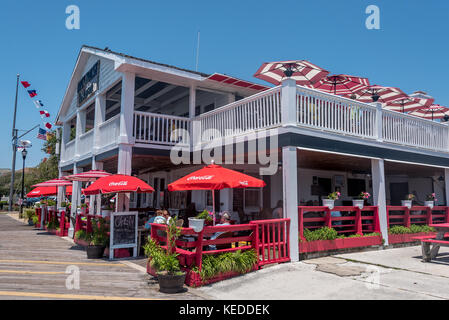 Der Dock House Restaurant auf der Beaufort Wasser auf der Crystal Coast von Nord-carolina, mit fröhlichen roten Sonnenschirmen und im Freien speisen. Stockfoto