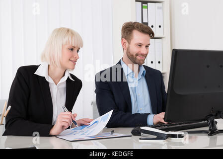 Zwei junge glücklich Geschäftsleute Arbeiten am Computer Stockfoto
