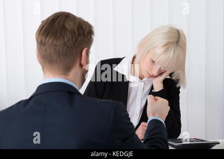 Nahaufnahme der Chef Schuld junge weibliche Mitarbeiter für schlechte Ergebnisse im Büro Stockfoto