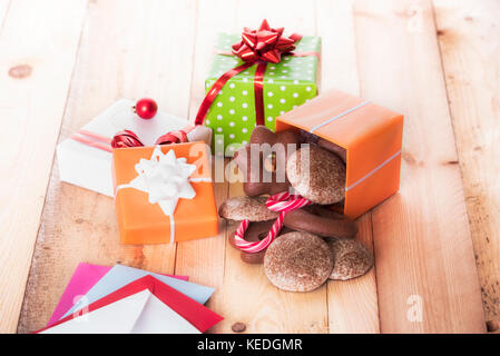 Bunte Geschenkboxen und Lebkuchen auf hölzernen Tisch Stockfoto