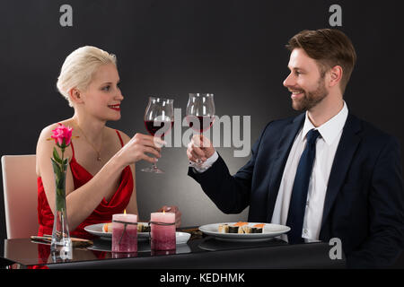 Junges Paar an einander, während Toasten Weingläser in einem Restaurant Stockfoto