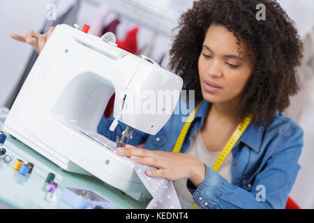 Gerne attraktive junge Frau Näherin Nähen auf der Maschine Stockfoto