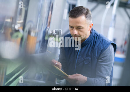 Reife männliche Inspector schreiben auf Zwischenablage in der Factory Stockfoto