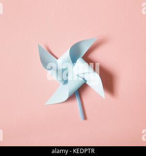 Blaues Papier Windrad auf rosa Hintergrund Stockfoto