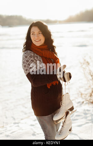 Fröhliche Frau Eis die Schlittschuhe stehen am Rand einer gefrorenen See Stockfoto