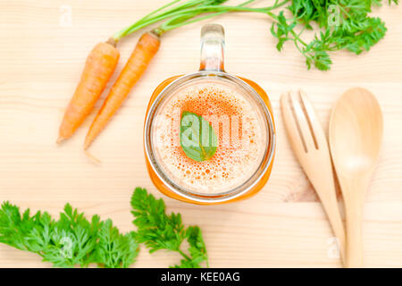 Gläser von Karottensaft mit Karotte Wurzeln auf Holz- Hintergrund. Gläser leckere frische Karottensaft. Karottensaft und Karotten. selektive Fokus dept von f Stockfoto