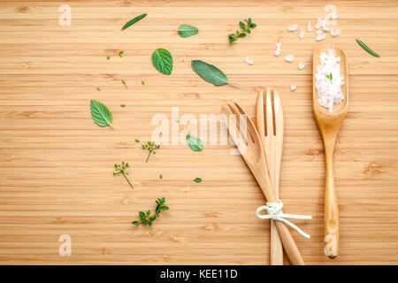 Aromatische Kräuter und Gewürze grüne Minze, Fenchel, Oregano, Salbei, Zitrone, Thymian und Pfefferminze mit Gabel und Meersalz auf Bambus Schneidebrett. Stockfoto