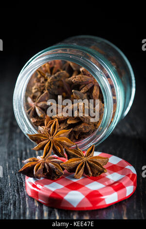 Ein Glas Glas mit Sternanis Samen auf einem dunklen Hintergrund Stockfoto