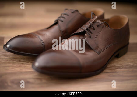 Elegante, braunem Leder männlichen Schuhe auf braunem Holz- Tabelle einstellen Stockfoto