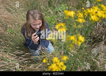 Junge Mädchen fotografieren Natur in Wäldern North Norfolk im Sommer (Model Released - Charlotte Tipling) Stockfoto