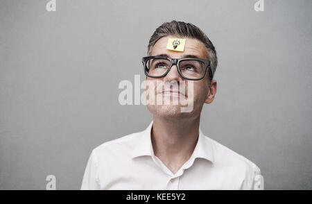 Forgetful nachlässig lächelnd Mann mit einem leeren Zettel auf der Stirn, Ideen und Planung Konzept Stockfoto