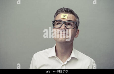 Forgetful nachlässig lächelnd Mann mit einem leeren Zettel auf der Stirn, Ideen und Planung Konzept Stockfoto