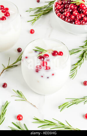 Ideen für Getränke für Weihnachten und Thanksgiving. White christmas margarita Punch mit Preiselbeeren und Rosmarin, auf einem weißen Marmor Tabelle, kopieren Raum Stockfoto