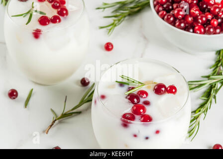 Ideen für Getränke für Weihnachten und Thanksgiving. White christmas margarita Punch mit Preiselbeeren und Rosmarin, auf weissem Marmortisch, Stockfoto