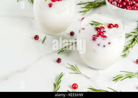 Ideen für Getränke für Weihnachten und Thanksgiving. White christmas margarita Punch mit Preiselbeeren und Rosmarin, auf einem weißen Marmor Tabelle, kopieren Raum Stockfoto