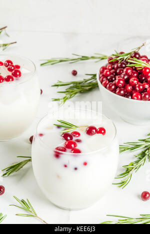 Ideen für Getränke für Weihnachten und Thanksgiving. White christmas margarita Punch mit Preiselbeeren und Rosmarin, auf weissem Marmortisch, Stockfoto