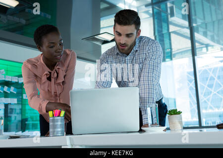 Führungskräfte diskutieren über Laptop am Schreibtisch im Büro Stockfoto