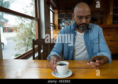 Mann mit Handy in cafÃƒÂ© Stockfoto