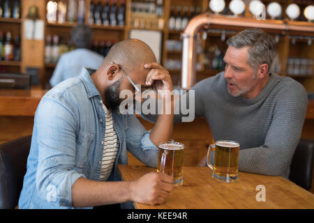 Mann tröstet seine depressiven Freund im Restaurant Stockfoto