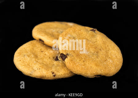 Chocolate chip und Rosinen Cookies mit Cranberry und isoliert auf einem schwarzen Hintergrund Stockfoto