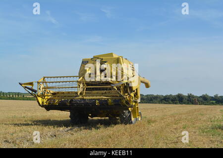 Alte offene Kabine gelb New Holland Mähdrescher Erntegut auf einem englischen Farm in 2017 Stockfoto