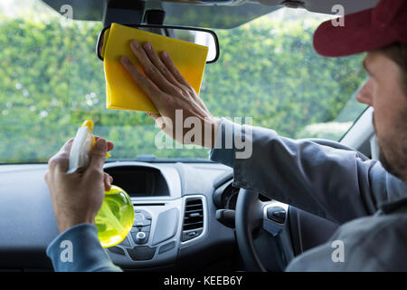 Männliche auto Service personal Reinigung Rückspiegel im Auto. Stockfoto