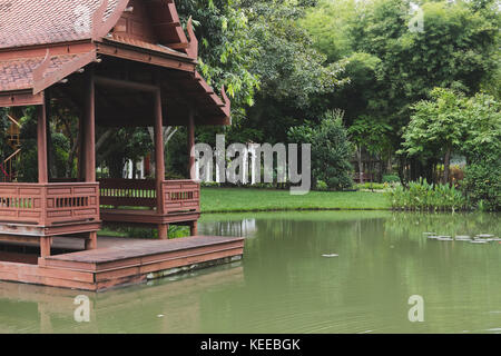 Traditionellen, thailändischen Pavillon auf der Wasserseite im Garten. Thailand Pavillon in der Nähe von Teich im Park. Stockfoto