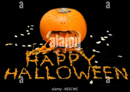 Einen geschnitzten Kürbis schaut zu erbrechen die Phrase happy halloween werden aus der Zellstoff Stockfoto