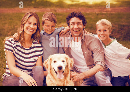 Porträt der Familie mit Hund im Park an einem sonnigen Tag Stockfoto