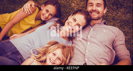 Portrait von Happy Family liegen auf Feld im Hinterhof Stockfoto