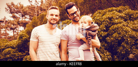 Happy homosexuelles Paar mit Kind im Garten Stockfoto