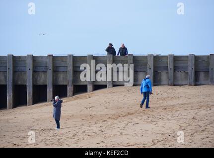 West Bay, Dorset, Großbritannien. Okt 2017 20. UK Wetter. Personen, die die relative Ruhe vor dem Sturm vorausgesagt, Großbritannien später heute auf einem sonnigen, aber stürmischen Tag am Strand zu schlagen. Credit: Dan Tucker/Alamy leben Nachrichten Stockfoto